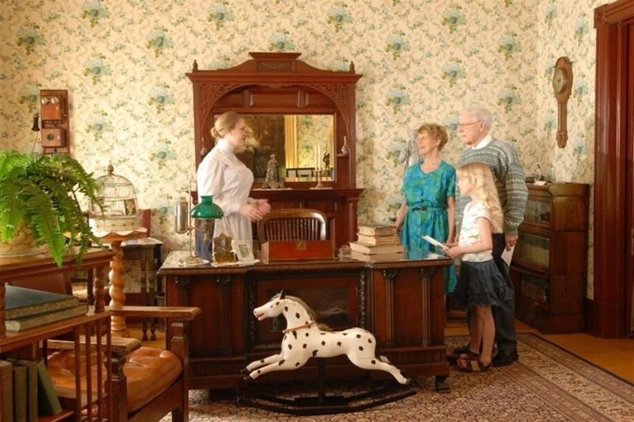 A costumed interpreter gives a tour to visitors in 